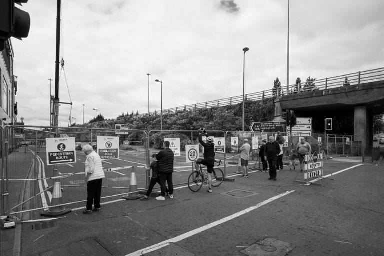 Onlookers watch cars being removed from car park