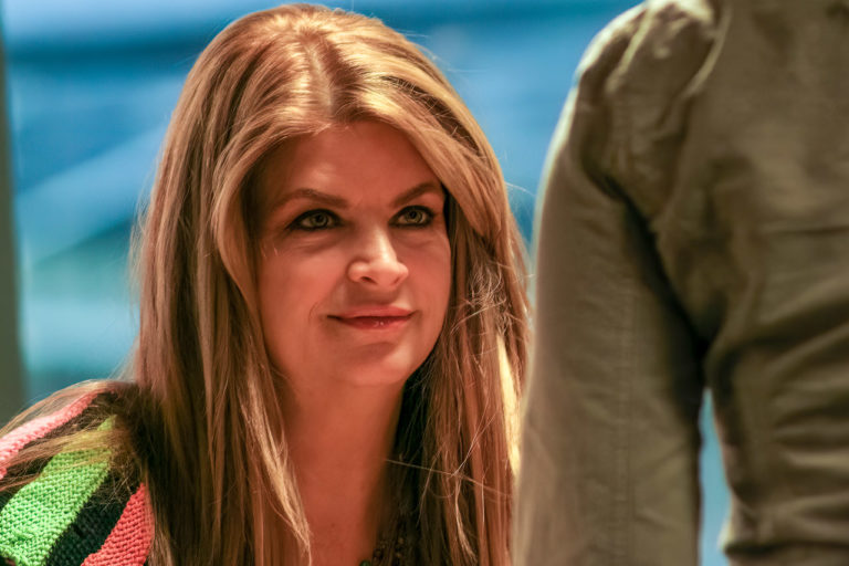 Close up of Kistie Alley looking up at another person.