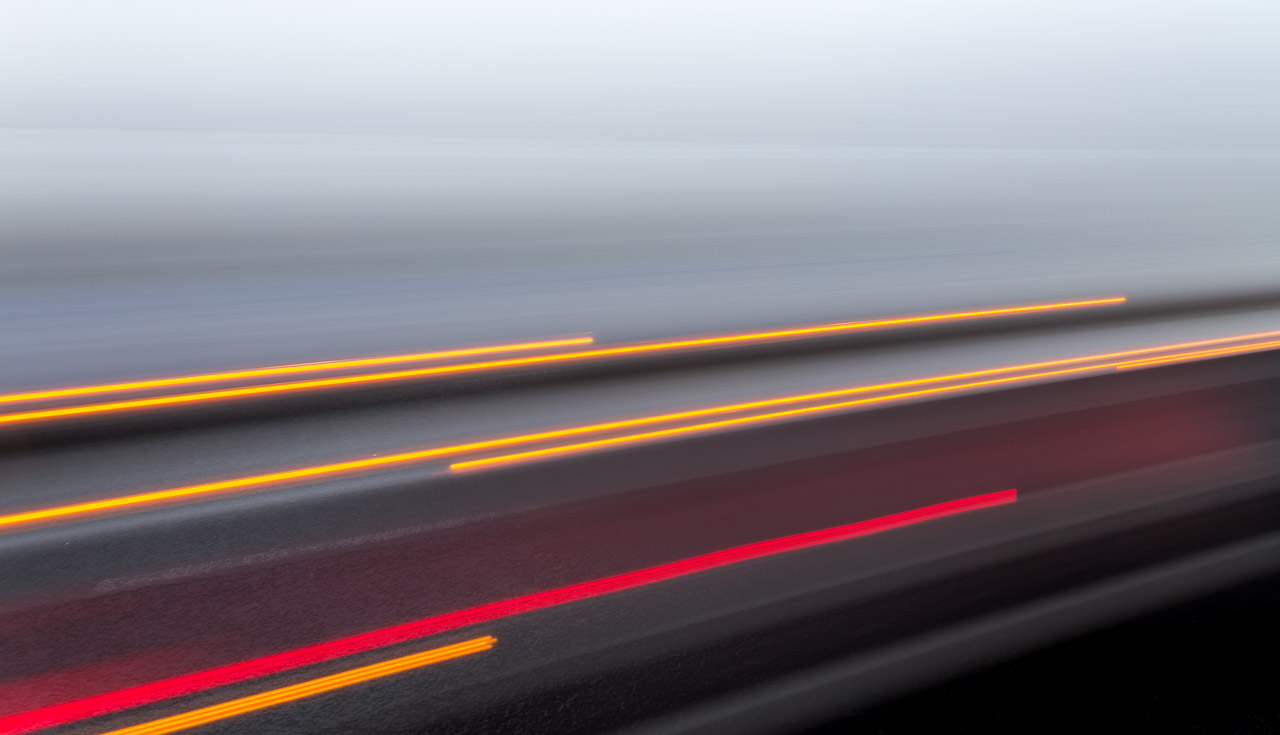 The Light trails of vehicles passing on the road.