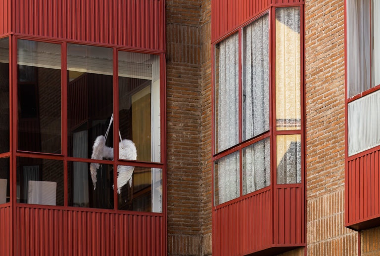 Angel's wings hang in the window of an apartment
