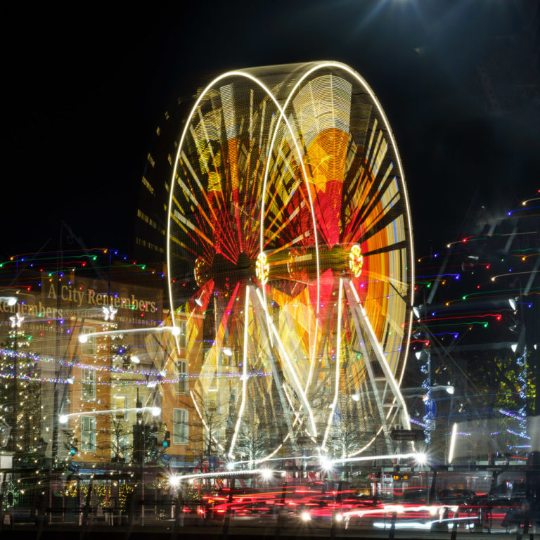 The lights of a Ferris Wheel appear doubled as the camera moved during exposure. Lots of other lights move too.