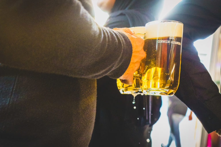 Someone carrying two litre glasses of beer through a crowd