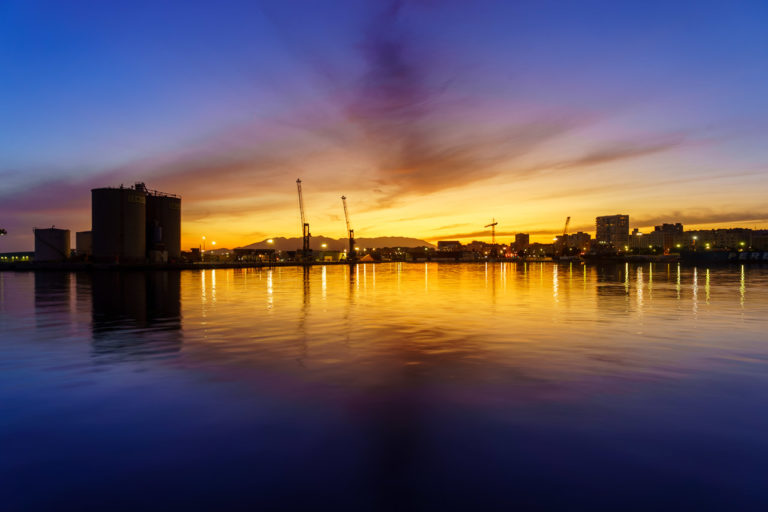 A wide angle view of the sun set, reflected in the water.