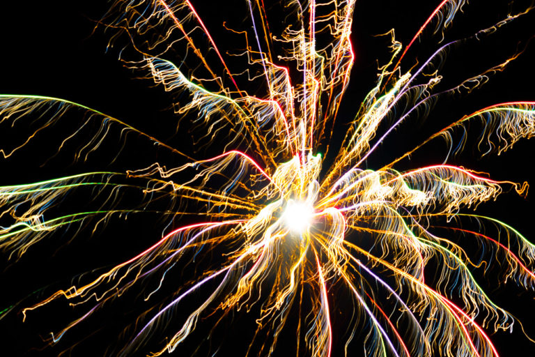 Bright fireworks burst in the sky in an explosion of colour