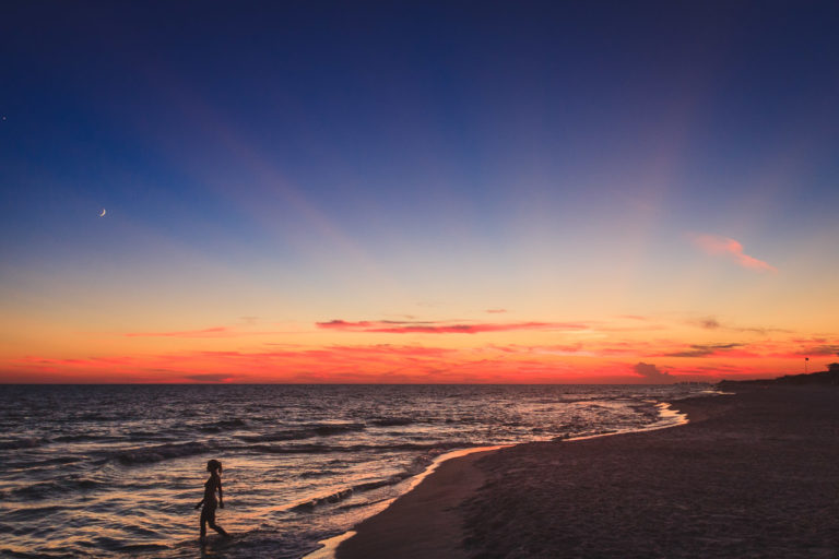 Sunrise on the beach at Seaside, Florida. A swimmer