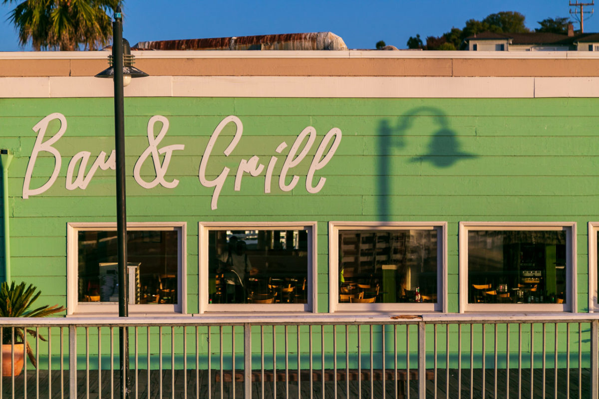 A restaurant in Santa Cruz in the early morning light. It says "Bar & Grill" on the side of the building
