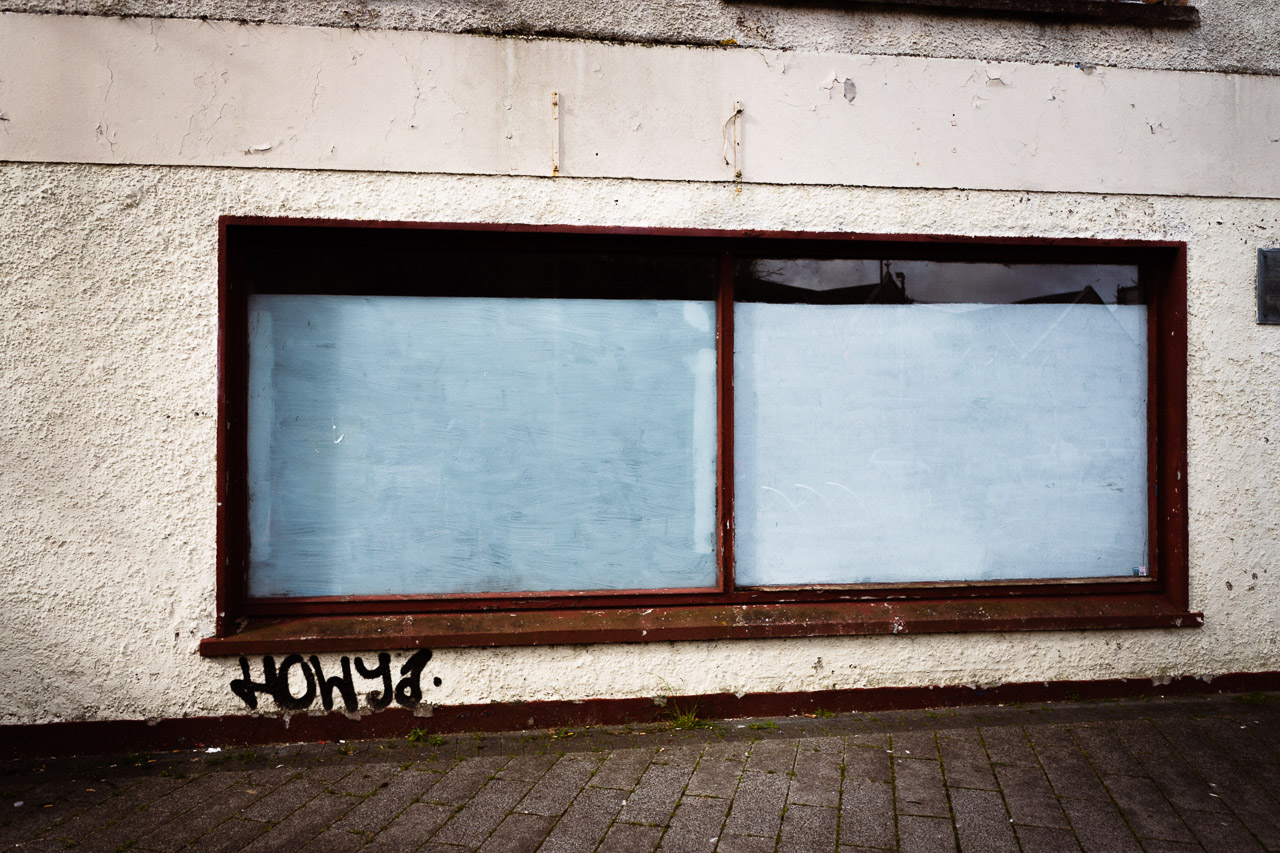 The window of a derelict building in Cork City with the greeting HOWYA on it.