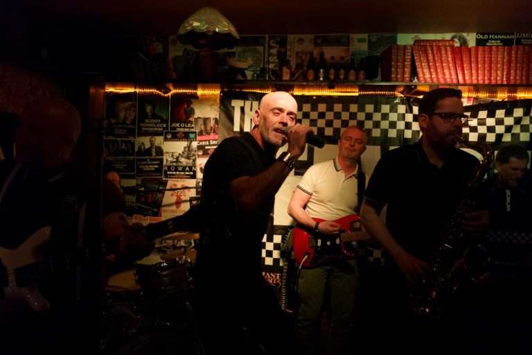 Members of the band, "The Service" performing on stage in Coughlans Bar.