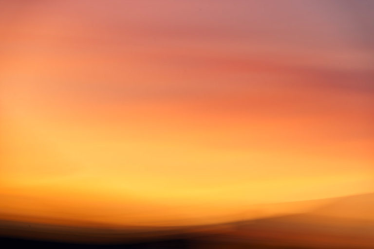 The yellow glow of sunset drowns out most other colours in an ICM photo of a sunset.