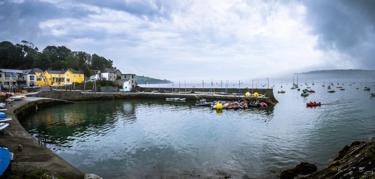 Boats dot the water outside Glandore Harbour and one comes in to the quay.