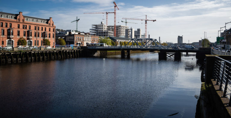 Construction Cranes were on site among the new buildings of Horgan's Quay in Cork. The River Lee is flowing in the foreground, crossed by Brian Boru Bridge nearby.