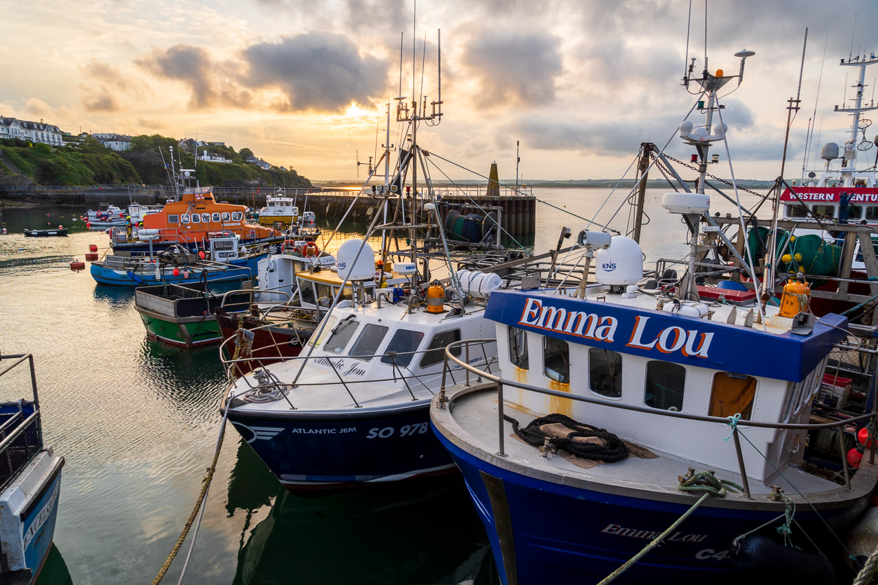 The boats of Ballycotton under a sunset. A fishing trawler with the name Emma Lou in the foreground.