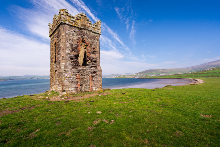 Hussey's Folly, a small 2 storey castle built in 1845 overlooks Dingle Harbour. Blue skies with whispy clouds above.