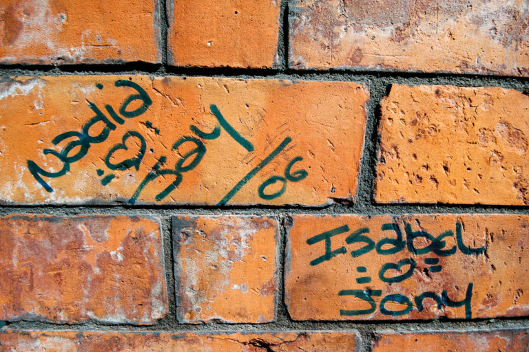 A brick wall with graffiti on it.