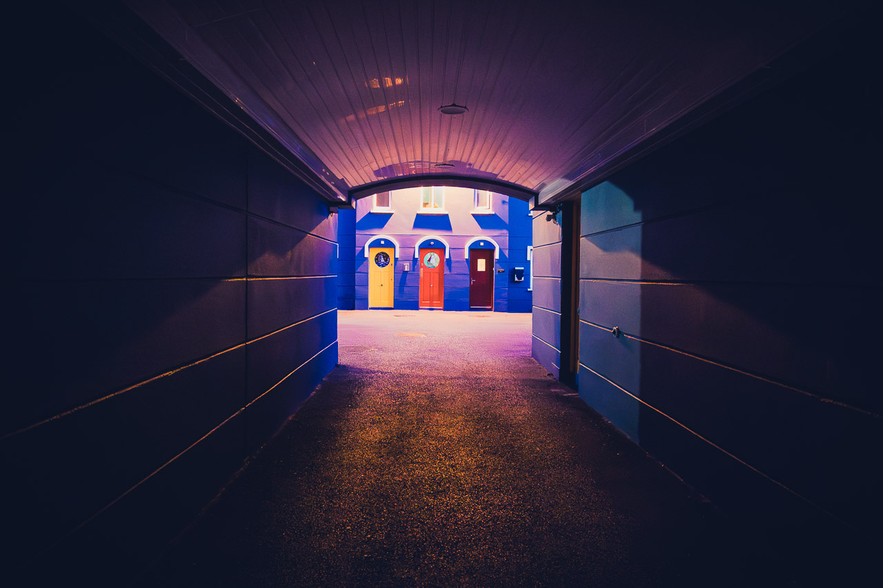 Looking through the tunnel to brightly coloured doors on homes in Cobh.
