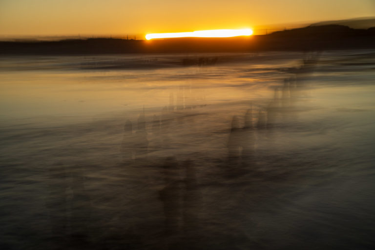 An ICM shot of the setting sun. The lens was swung horizontally meaning the sun left a trail on the horizon and the groynes in the sea are like transparent shadows