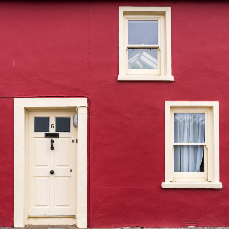 A red house with cream colour window frames and front door.