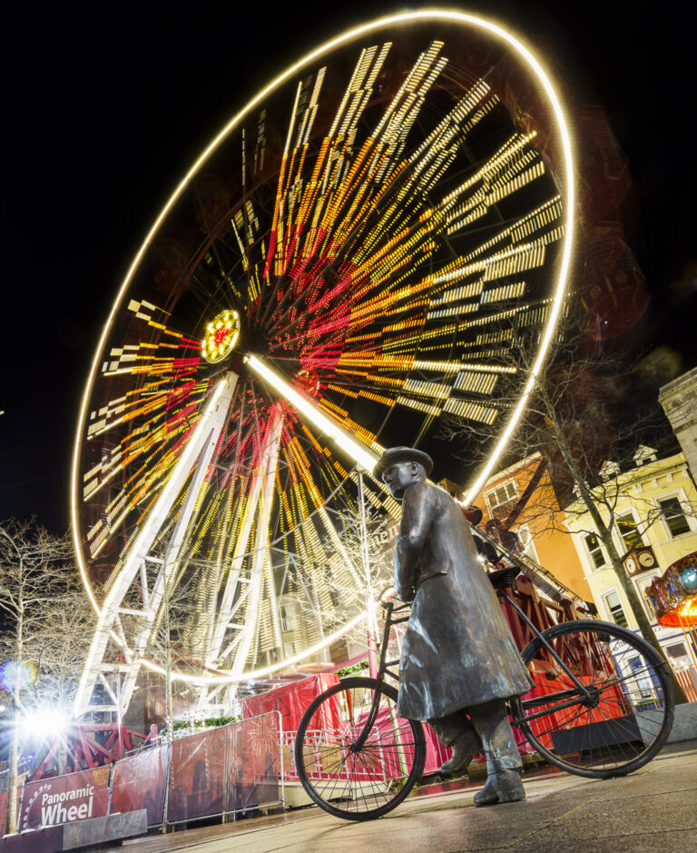 The statue of Michael Collins in front of the big wheel on Grand Parade, Cork.