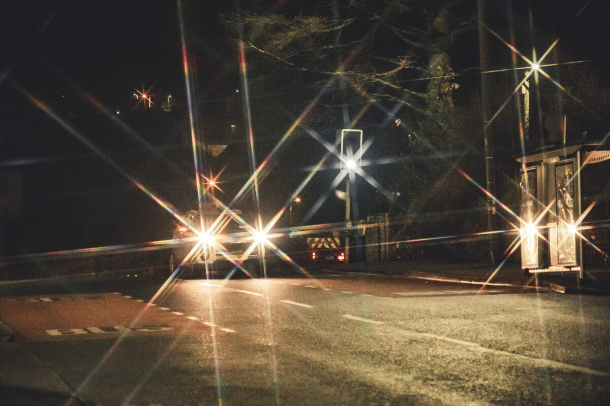 A car driving on the road at night with the lights making stars.