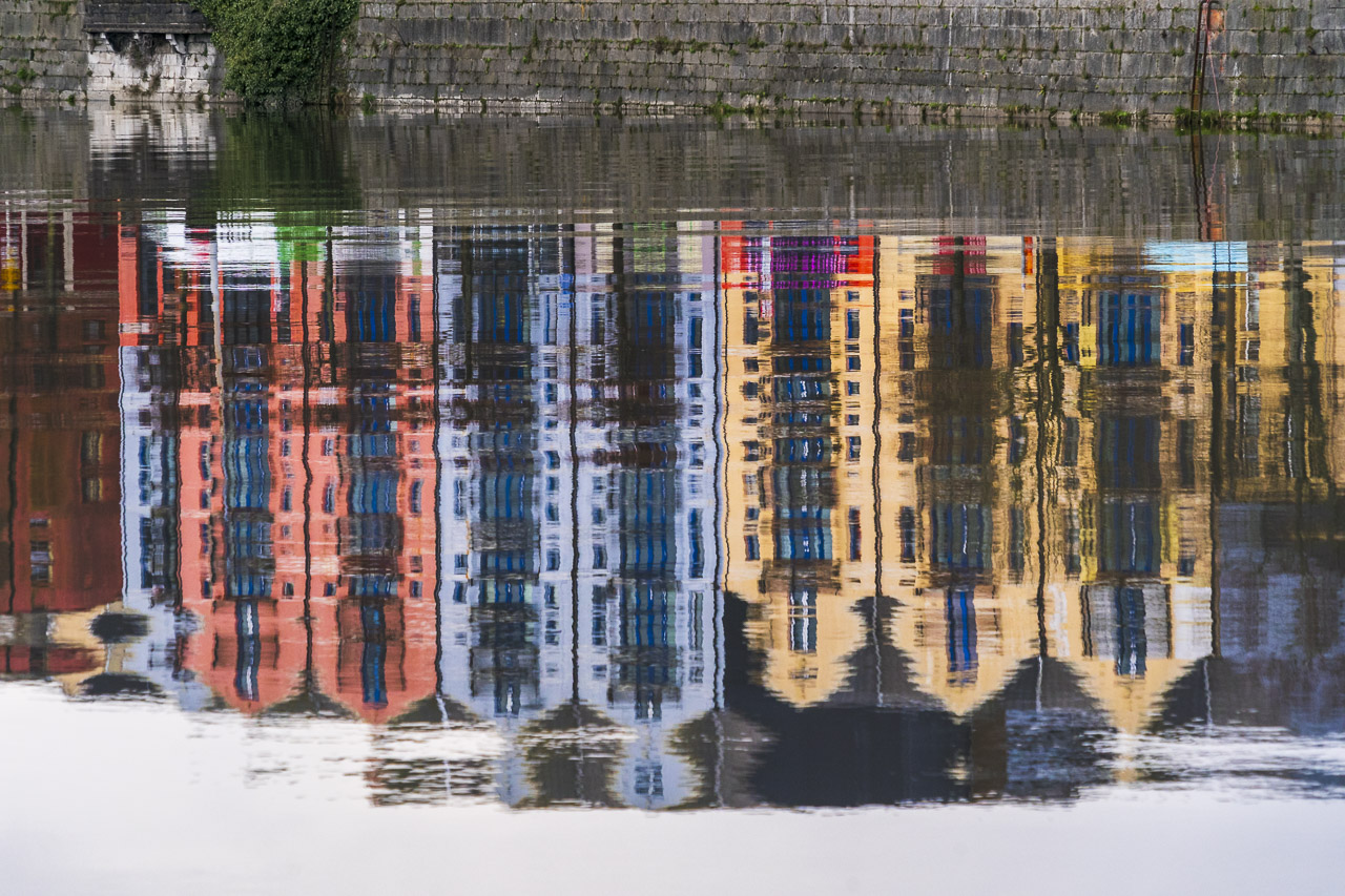 The colourful buildings of Pope's Quay in Cork are reflected in the water of the River Lee.