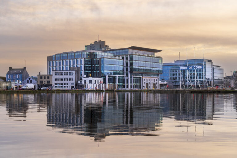 Various buildings on Albert Quay in Cork are reflected in the River Lee one early morning just after sunrise when the sky is coloured by the rising the sun.