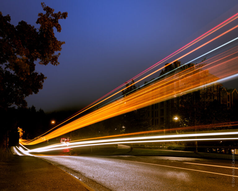 Light from a passing truck is captured on a long exposure photo as it drives by.