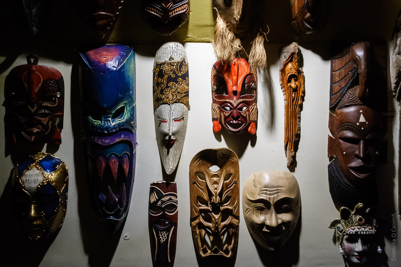 Masks hanging on a wall in a pub. The wall behind is white while the masks defy description, sorry!