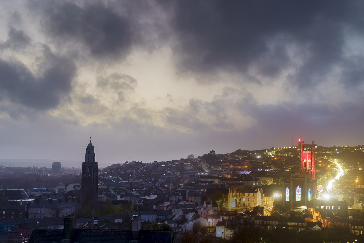 A time blend of the north side of Cork City with The North Cathedral and the steeple of St. Anne's Church, or Shandon Bells visible.