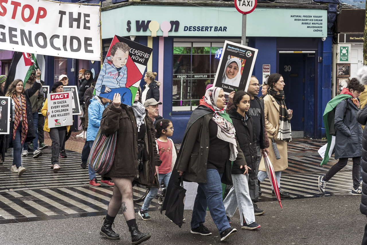 People walking in a rally in support of Gaza. Some carry posters and flags.