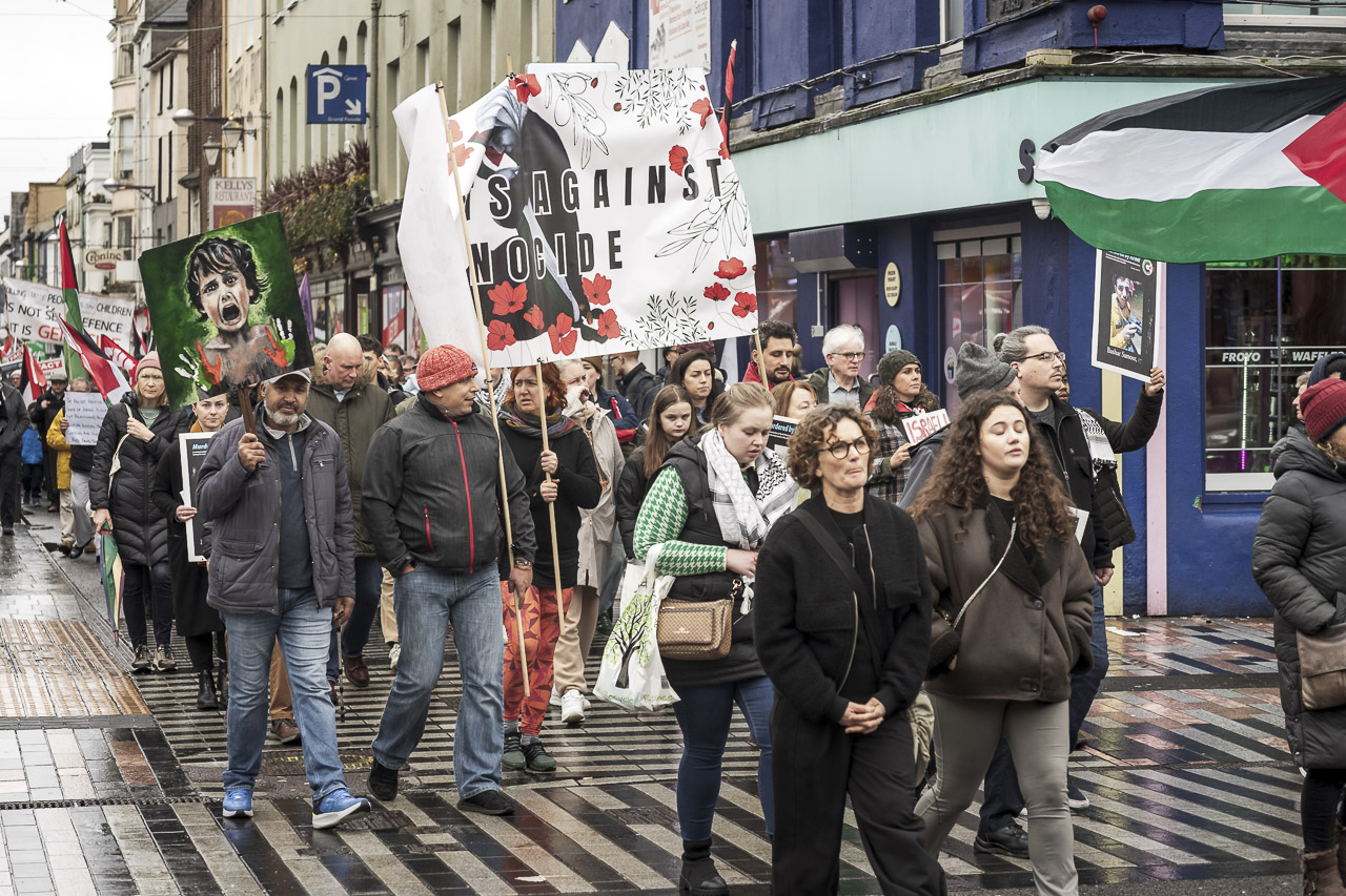 People walking in a rally in support of Gaza. Some carry posters and flags.