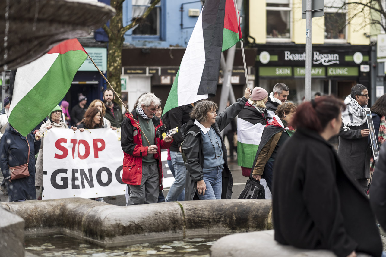 People walking in a rally in support of Gaza. Some carry posters and flags.