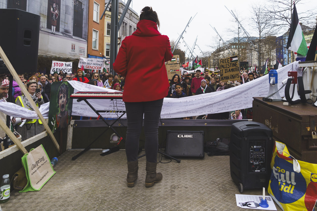 A speaker in front of the crowd on Grant Parade.