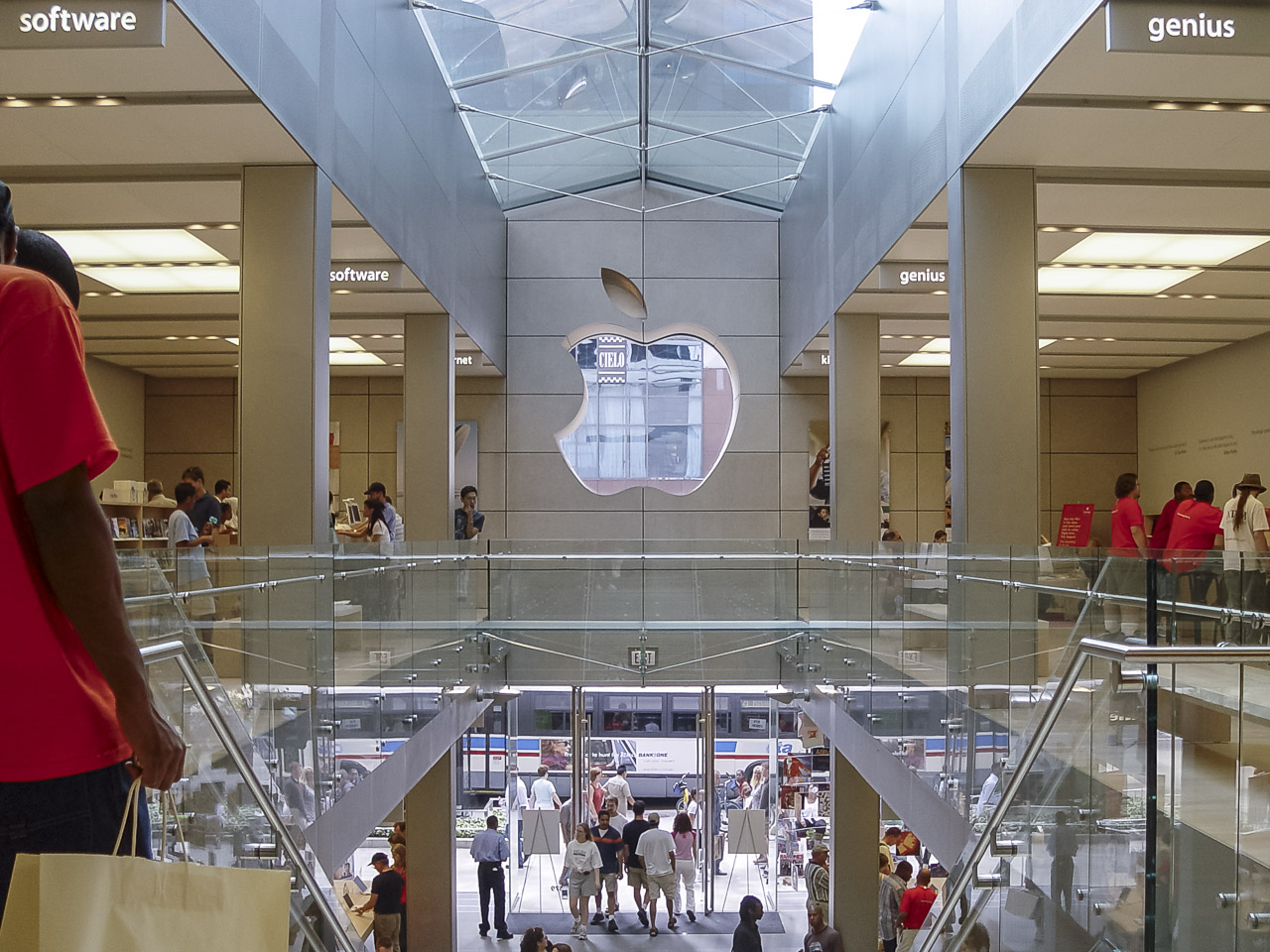 Inside an Apple store in Chicago. upstairs, facing the stairs. The apple logo in the wall is a window on to the street.