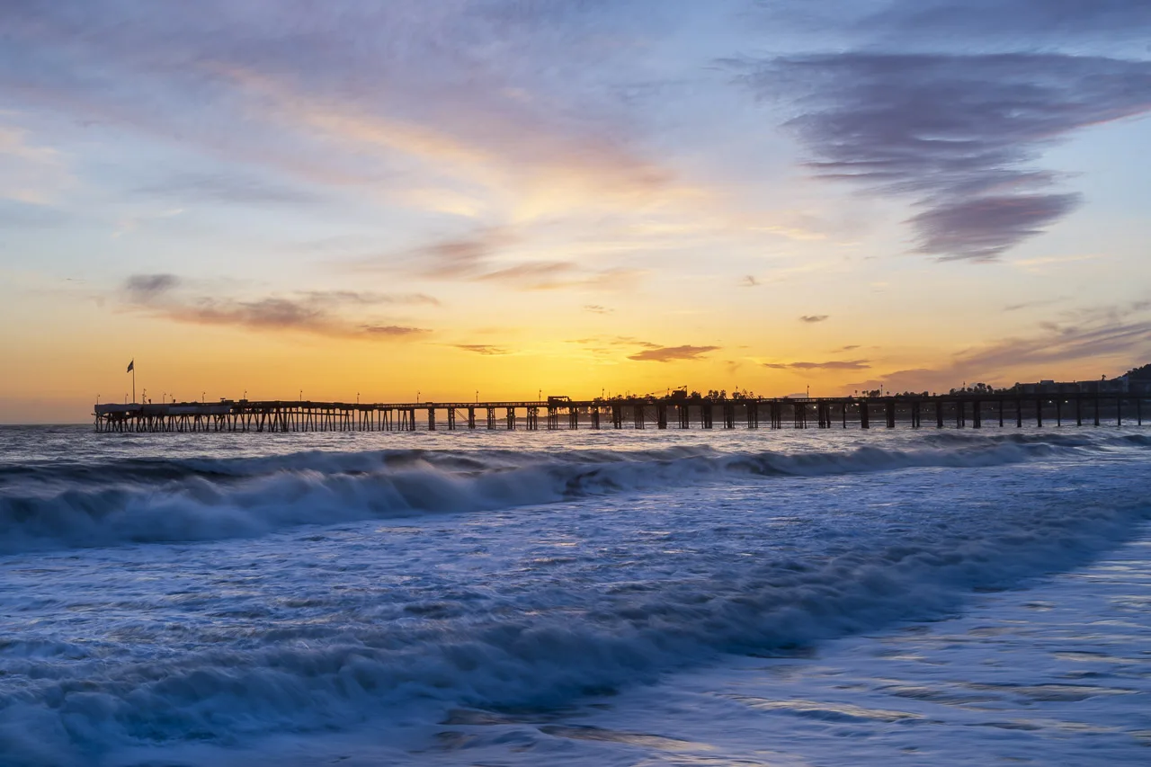 Just after sunset looking out on the Pacific at the Ventura Beach Pier. Waves roll in in the foreground.