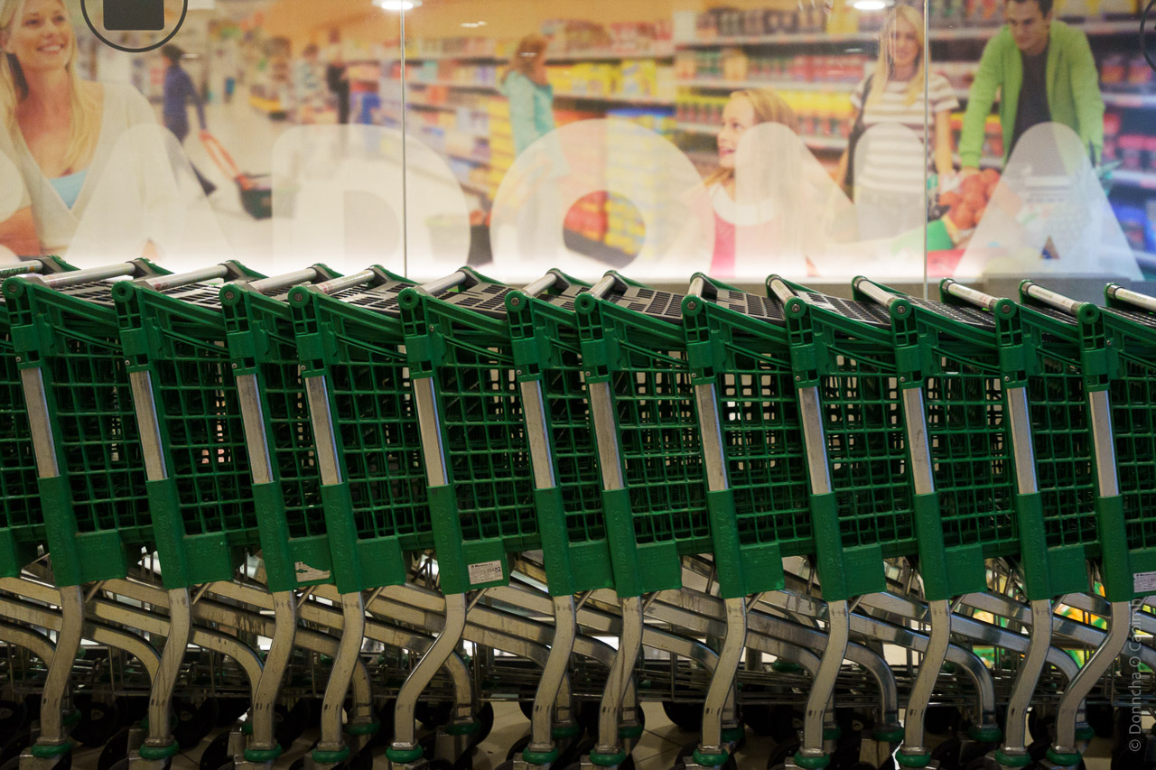 Shopping trolleys (or carts), ready to be used by customers are stored just outside the shop.